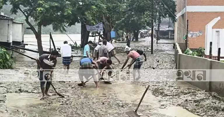 বন্যার পানি সরে যাওয়ার পর কাদামাটি অপসারণ